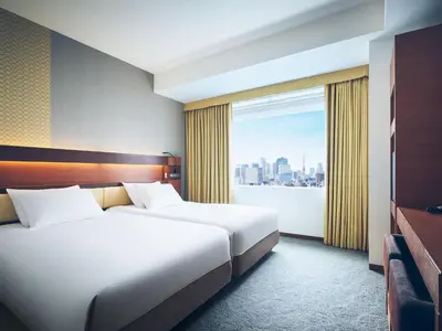 two beds in a hotel room with a window at Lotte City Hotel Kinshicho in Tokyo