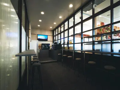 a bar with stools in a room with windows at Lotte City Hotel Kinshicho in Tokyo