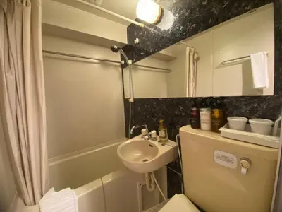 a small bathroom with a sink and a toilet at HOTEL LiVEMAX BUDGET Higashi Ueno in Tokyo