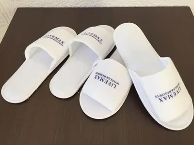 a group of white slippers sitting on a table at HOTEL LiVEMAX BUDGET Korakuen in Tokyo