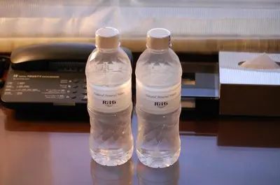 two water bottles sitting on a desk next to a telephone at Hotel Trusty Tokyo Bayside in Tokyo
