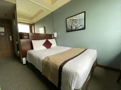 a hotel room with a bed with a red pillow at Hotel Trusty Tokyo Bayside in Tokyo