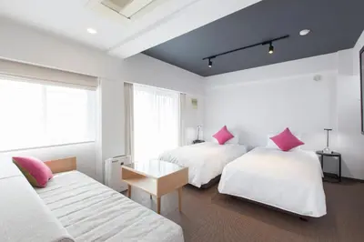 two beds with pink pillows in a white room at Tokyu Stay Meguro Yutenji in Tokyo