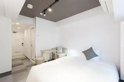 a bedroom with a white bed and a table at Tokyu Stay Meguro Yutenji in Tokyo