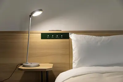 a lamp sitting on a table next to a bed at Tokyu Stay Meguro Yutenji in Tokyo