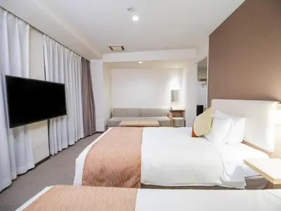 a hotel room with a bed and a flat screen tv at Tokyu Stay Nihonbashi in Tokyo