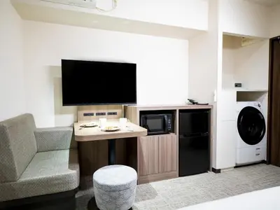 a living room with a tv and a couch and a chair at Tokyu Stay Nihonbashi in Tokyo