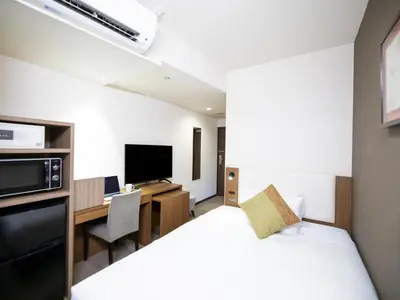 a hotel room with a bed and a desk and a tv at Tokyu Stay Nihonbashi in Tokyo