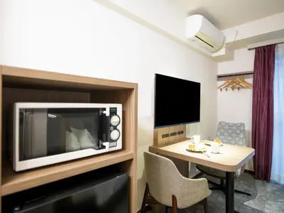a hotel room with a table and a microwave at Tokyu Stay Nihonbashi in Tokyo