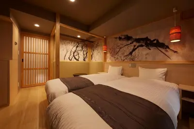 a bedroom with two beds and a painting on the wall at Sakura Sky Hotel in Tokyo