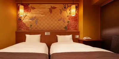 two beds sitting next to each other in a room at Sakura Sky Hotel in Tokyo
