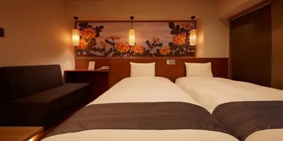 a hotel room with two beds and a couch at Sakura Sky Hotel in Tokyo