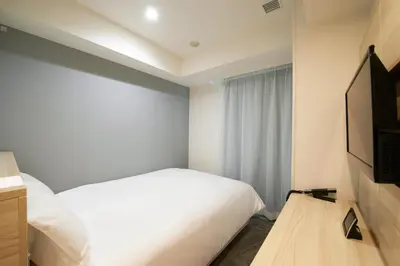 a bedroom with a white bed and a window at Sotetsu Fresa Inn Ueno-Okachimachi in Tokyo