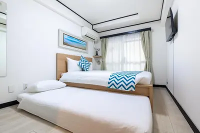 a bedroom with two beds and a window at G-stays Shinjuku in Tokyo