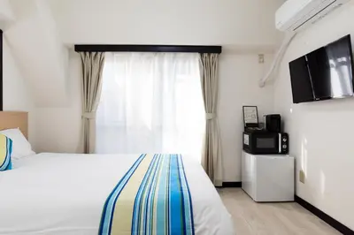 a hotel room with a bed and a window at G-stays Shinjuku in Tokyo