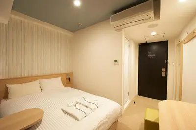 a bedroom with a bed with two towels on it at Sotetsu Fresa Inn Ginza Sanchome in Tokyo