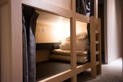 a bunk bed with pillows and a blanket at TOKYO-W-INN Asakusa in Tokyo