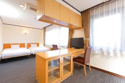a hotel room with a desk with a television at FLEXSTAY INN Sugamo in Tokyo