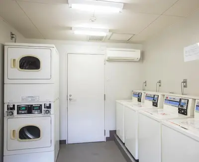 a laundry room with washing machines and sinks at FLEXSTAY INN Sugamo in Tokyo