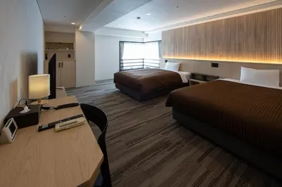 a hotel room with two beds and a desk at Belmont Hotel in Tokyo
