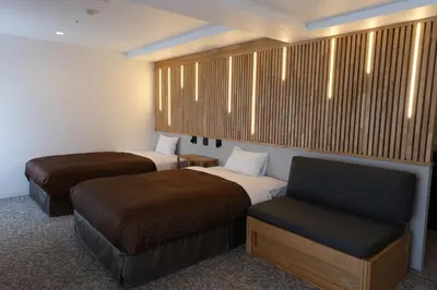 a hotel room with two beds and a chair at Belmont Hotel in Tokyo