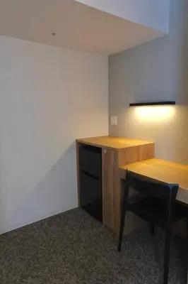 a room with a desk and a table and a chair at Belmont Hotel in Tokyo