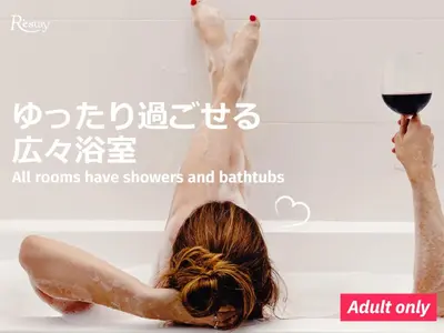 a woman laying in a bath with a glass of wine at Restay Frontier (Adult Only) in Tokyo