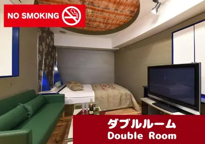 a living room with a tv and a green couch at Restay Frontier (Adult Only) in Tokyo