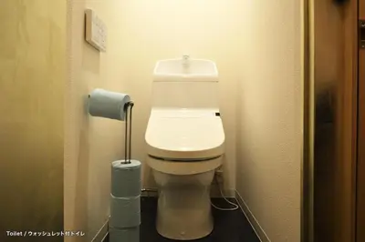 a toilet in a bathroom with a roll of toilet paper at Tokyo Tower View Guest House in Tokyo
