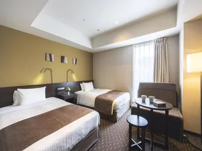 a hotel room with two beds and a chair at Akihabara Washington Hotel in Tokyo