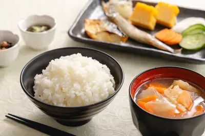a table with a bowl of rice and a plate of food at Akihabara Washington Hotel in Tokyo