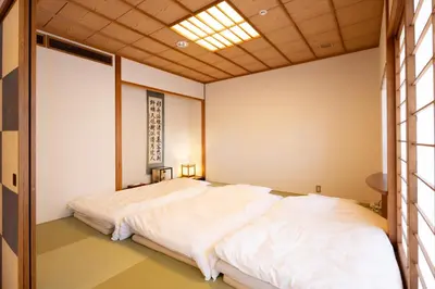 a bedroom with a large white bed in it at Ryokan Asakusa Shigetsu in Tokyo