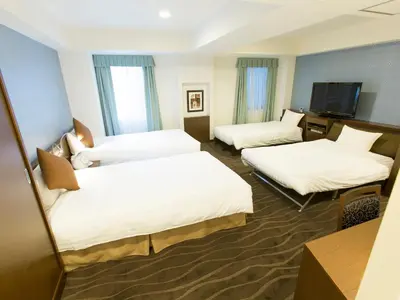 a hotel room with two beds and a flat screen tv at Shibuya Tobu Hotel in Tokyo