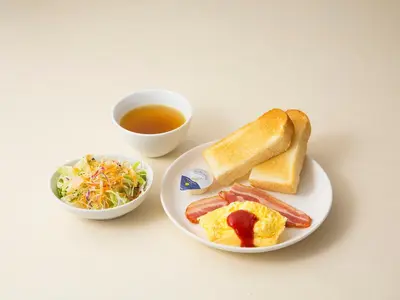a table with a plate of breakfast foods and a cup of soup at Shibuya Tobu Hotel in Tokyo