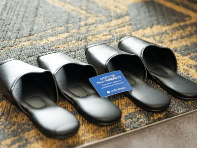 a group of black shoes sitting on a rug at HOTEL MYSTAYS Kanda in Tokyo
