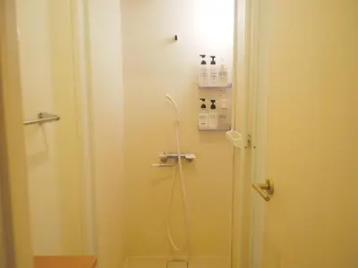 a shower in a bathroom with the door open at bnb+ Akihabara (Female Only) in Tokyo
