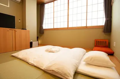 a large white bed in a room with a window at Nagomi Hotel Nippori in Tokyo