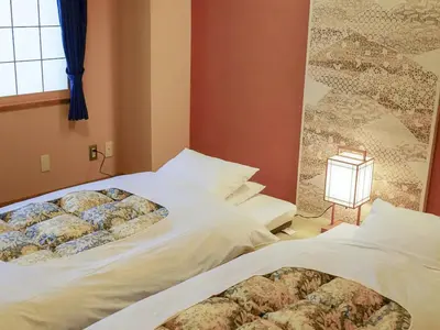 a bedroom with two beds and a window at Ryokan Kamogawa Asakusa in Tokyo