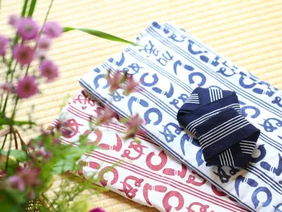 a stack of napkins sitting on a table with flowers at Ryokan Kamogawa Asakusa in Tokyo