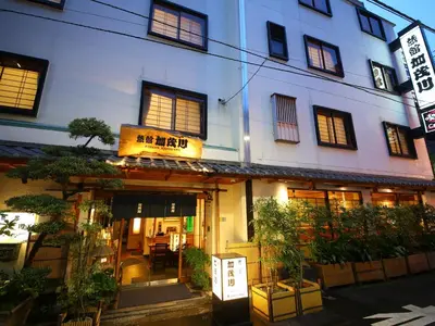 a building with a sign in front of it at Ryokan Kamogawa Asakusa in Tokyo
