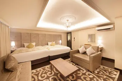 a hotel room with a large bed and a couch at The Centurion Classic Akasaka in Tokyo
