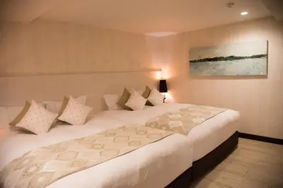 a bedroom with a large white bed with pillows at The Centurion Classic Akasaka in Tokyo