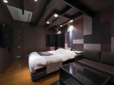 a bedroom with a bed and a couch at Hotel Crest Kinshicho (Adult Only) in Tokyo
