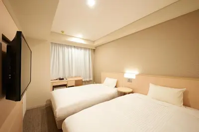 a hotel room with two beds and a television at Sotetsu Fresa Inn Tokyo Kinshicho in Tokyo