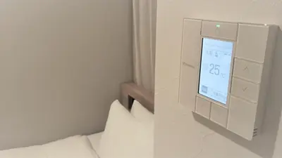a room with a bed and a wall with a clock at Sotetsu Fresa Inn Tokyo Kinshicho in Tokyo