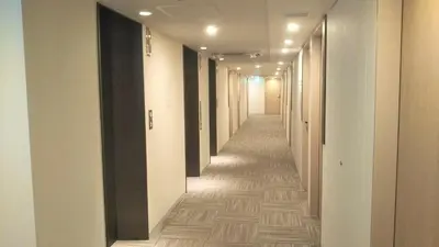 a hallway with a long corridor with white and black walls at Sotetsu Fresa Inn Tokyo Kinshicho in Tokyo