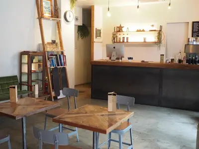 a restaurant with tables and chairs and a counter at almond hostel & cafe Shibuya in Tokyo