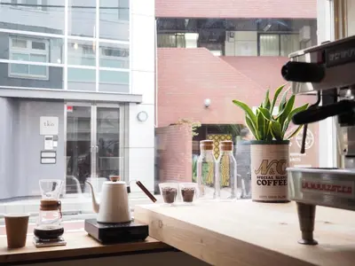 a wooden counter with glasses and bottles on a window at almond hostel & cafe Shibuya in Tokyo
