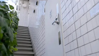 a staircase leading up to a building with a door at almond hostel & cafe Shibuya in Tokyo