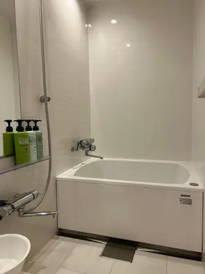 a white bathroom with a tub and a sink at Tokyo Ueno New Izu Hotel in Tokyo